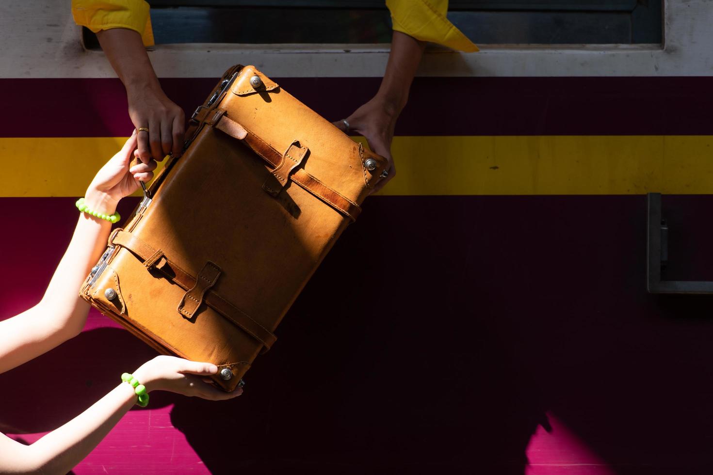 un hombre en el tren recogiendo una maleta clásica de una mujer amada foto