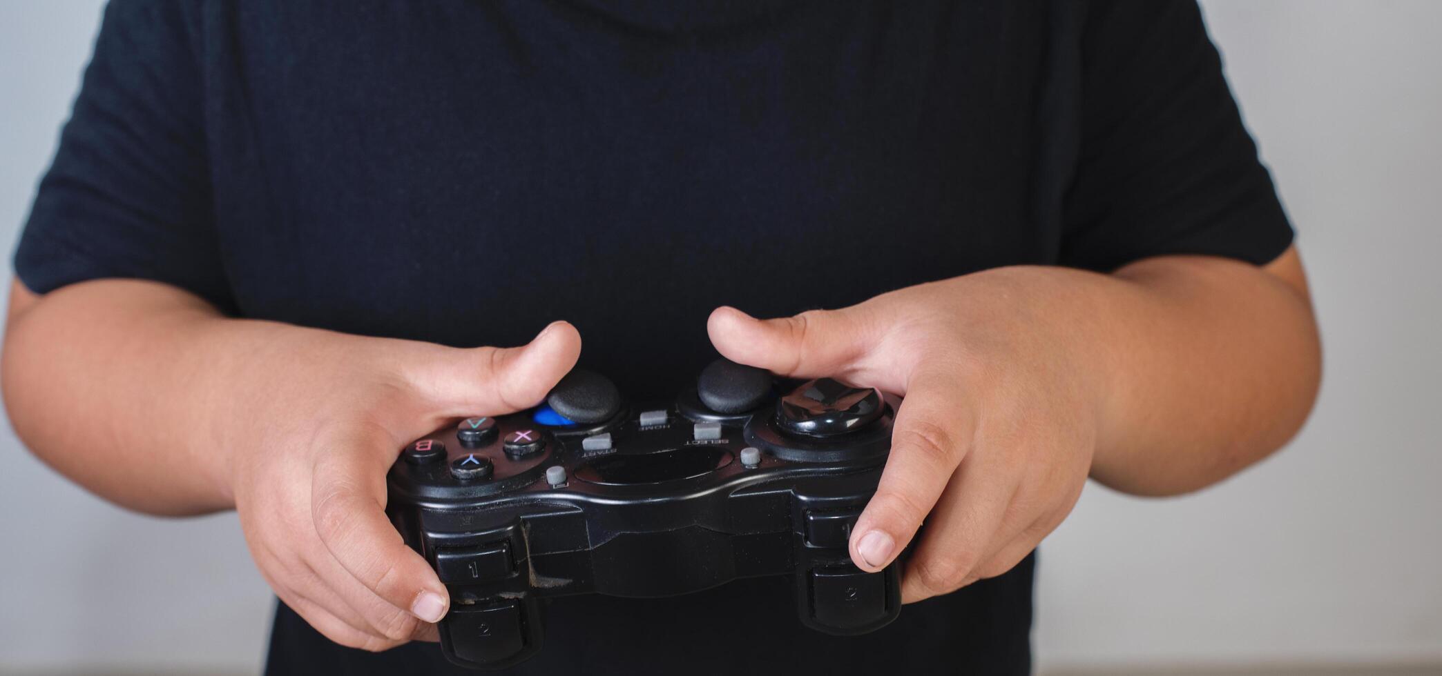 Happy boy play game computer with a controller in studio photo