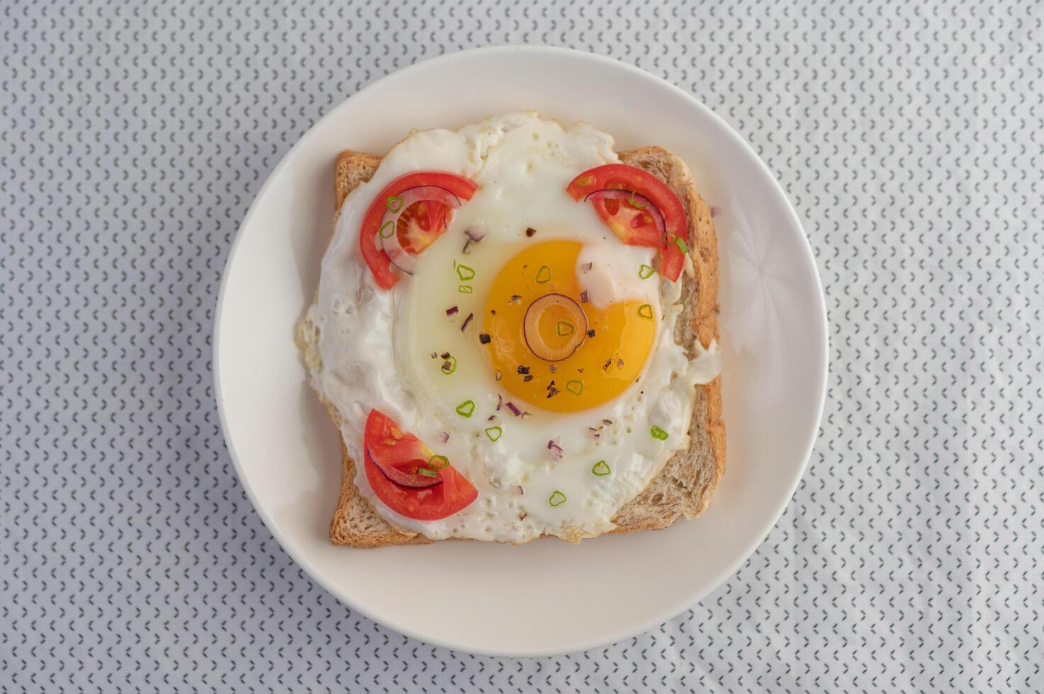 pan colocado con un huevo frito con tomates, harina de tapioca. foto