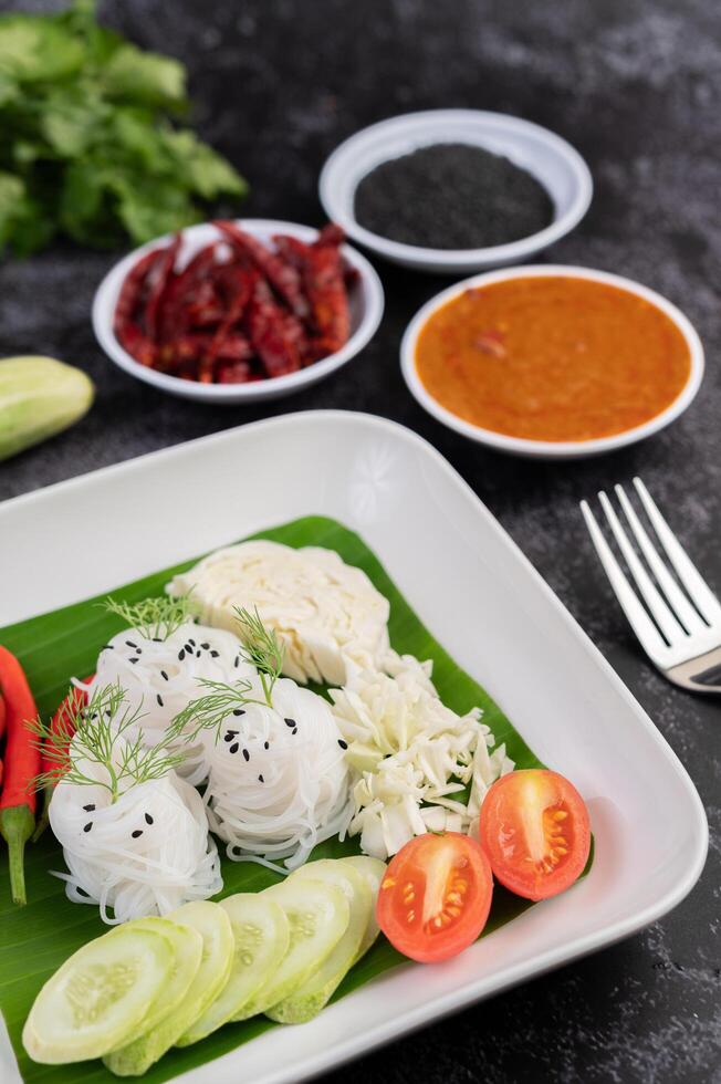 Noodles in a banana leaf with beautifully laid vegetables and side dishes. Thai food. photo