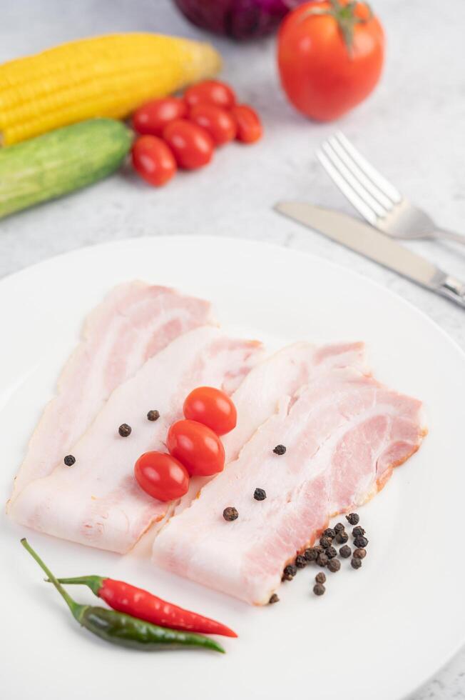 cerdo un plato blanco con semillas de pimiento y tomates. foto