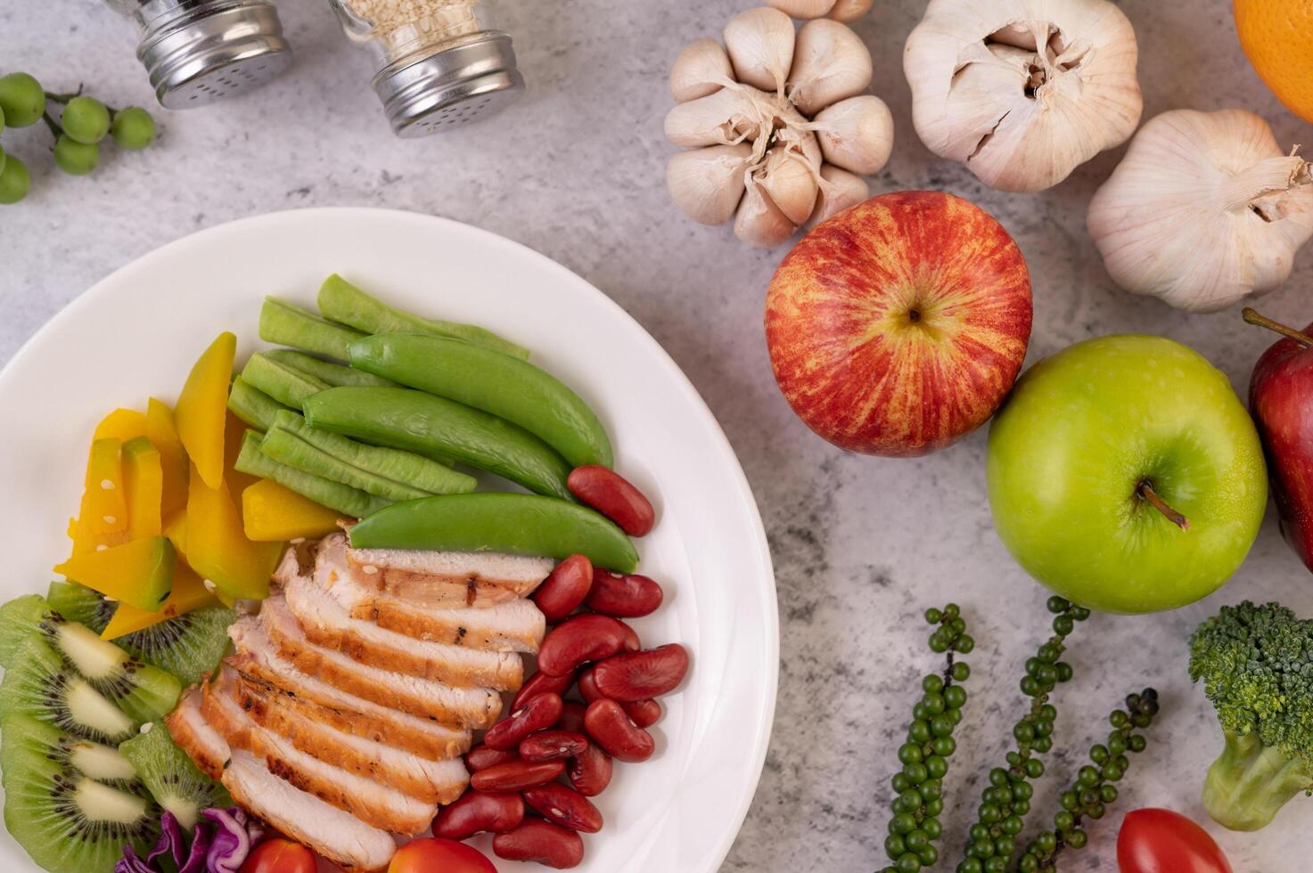 filete de pollo con guisantes, tomates, kiwi y calabaza. foto