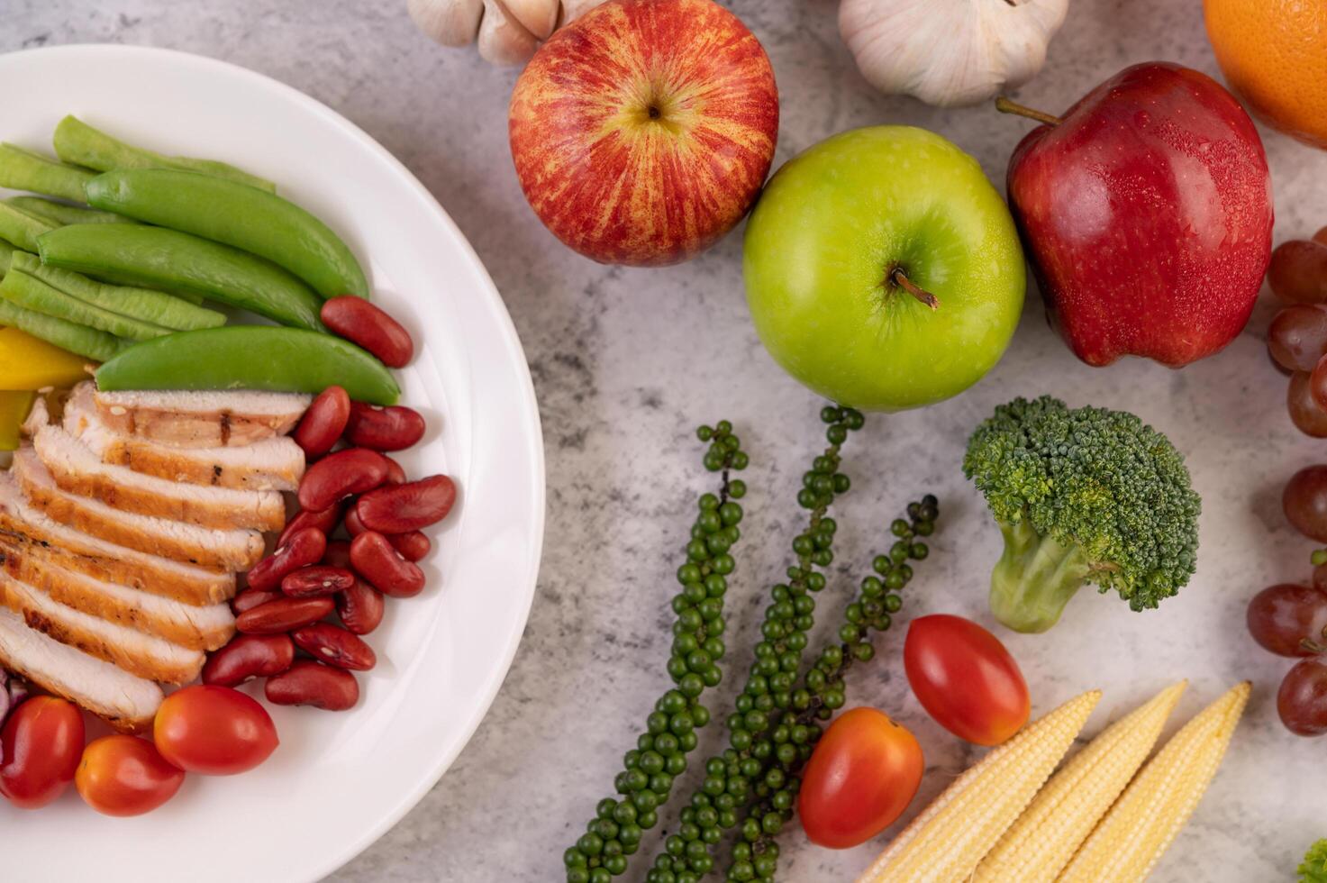 Chicken steak with peas, tomatoes, kiwi and pumpkin. photo