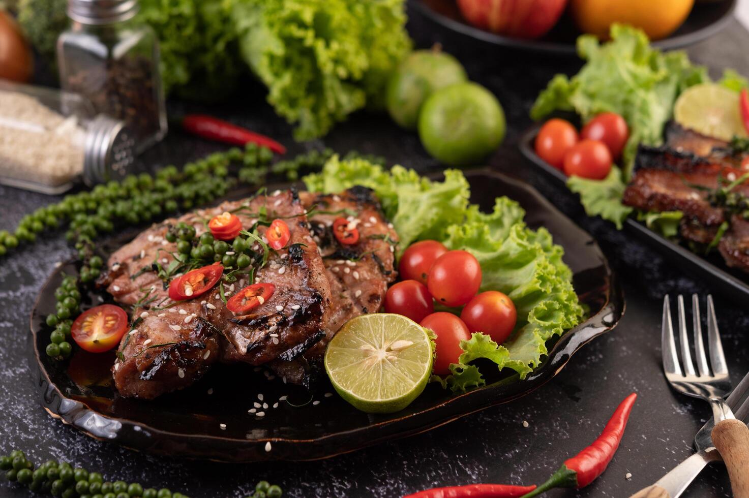 Pork steak topped with white sesame and fresh pepper seeds along. photo