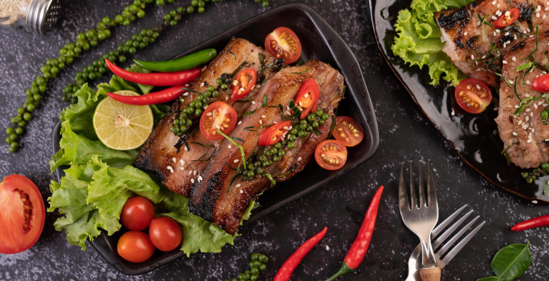 Pork steak topped with white sesame and fresh pepper seeds along. photo