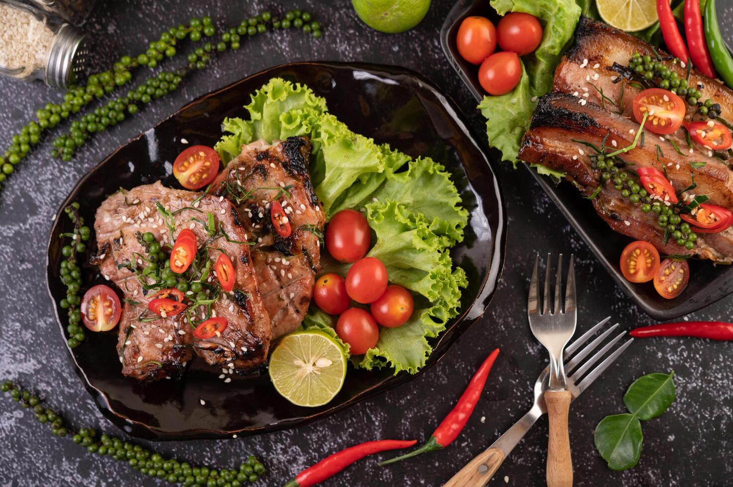 Pork steak topped with white sesame and fresh pepper seeds along. photo