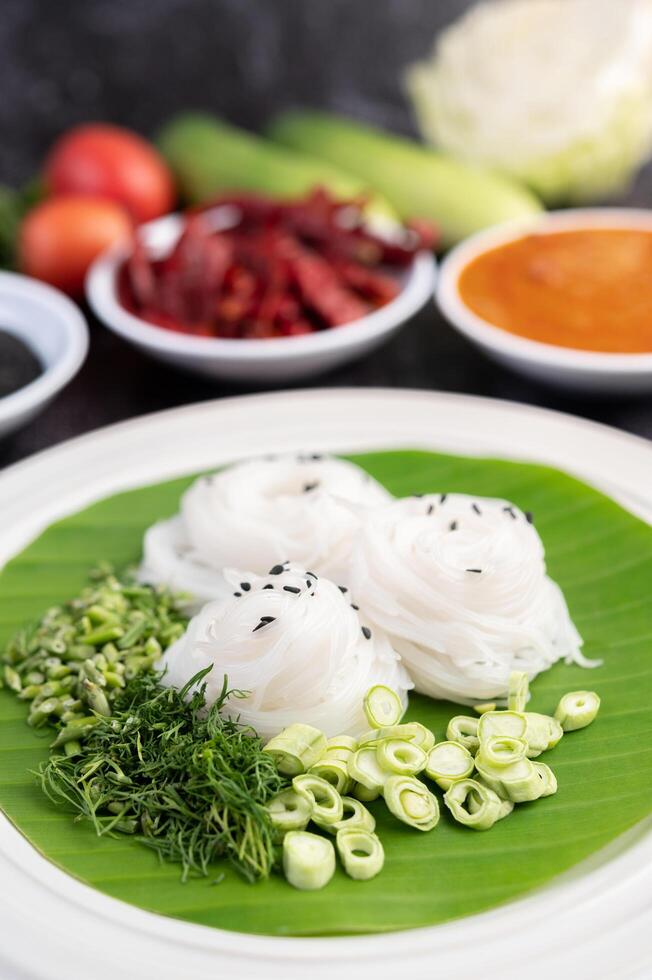 Noodles in a banana leaf with beautifully laid vegetables and side dishes. Thai food. photo