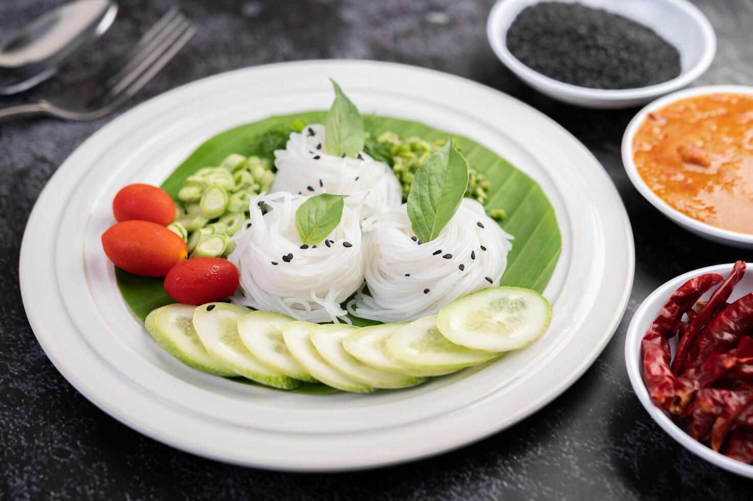 Noodles in a banana leaf with beautifully laid vegetables and side dishes. Thai food. photo