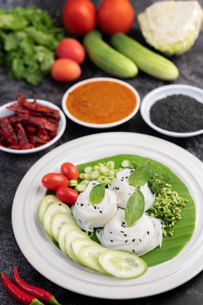 fideos en una hoja de plátano con verduras y guarniciones bellamente colocadas. comida tailandesa. foto