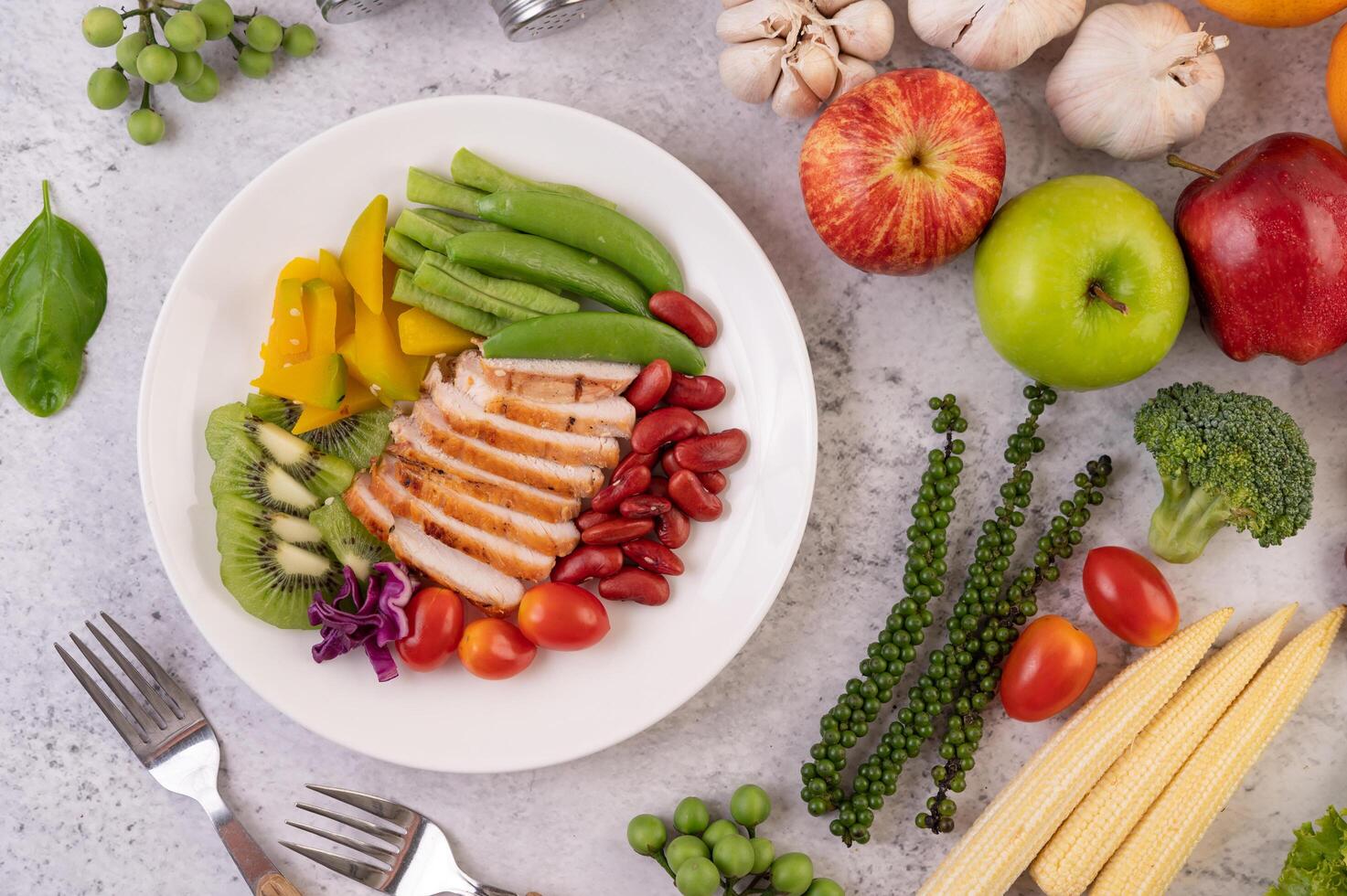 filete de pollo con guisantes, tomates, kiwi y calabaza. foto