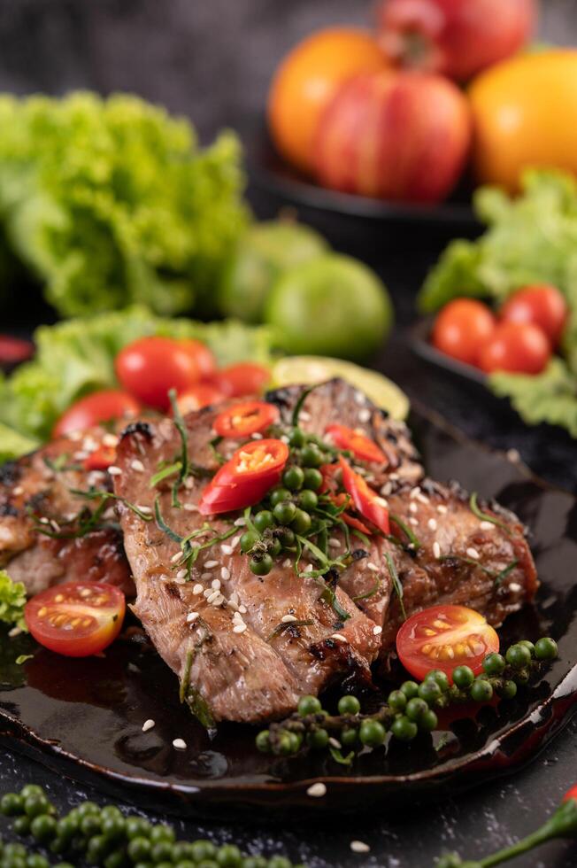 Pork steak topped with white sesame and fresh pepper seeds along. photo