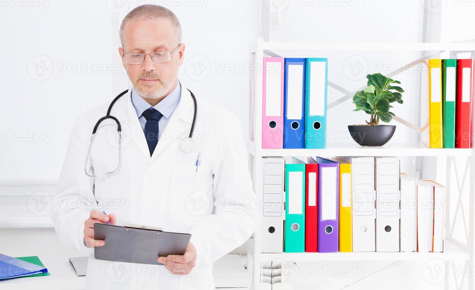 doctor writes something in folder in the clinic office photo