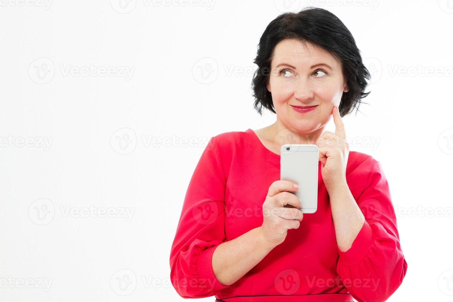 Attractive middle-aged woman relaxing reading her text messages on her mobile phone with a quiet smile copy space photo
