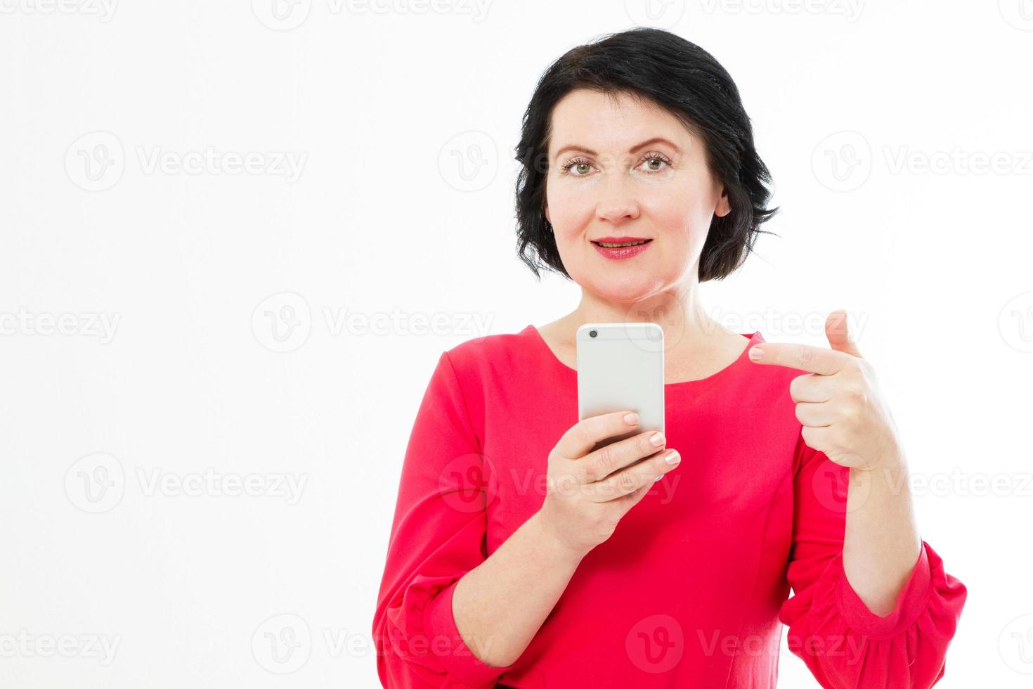 Beautiful middle age woman holding phone pointed on phone isolated on white copy space photo