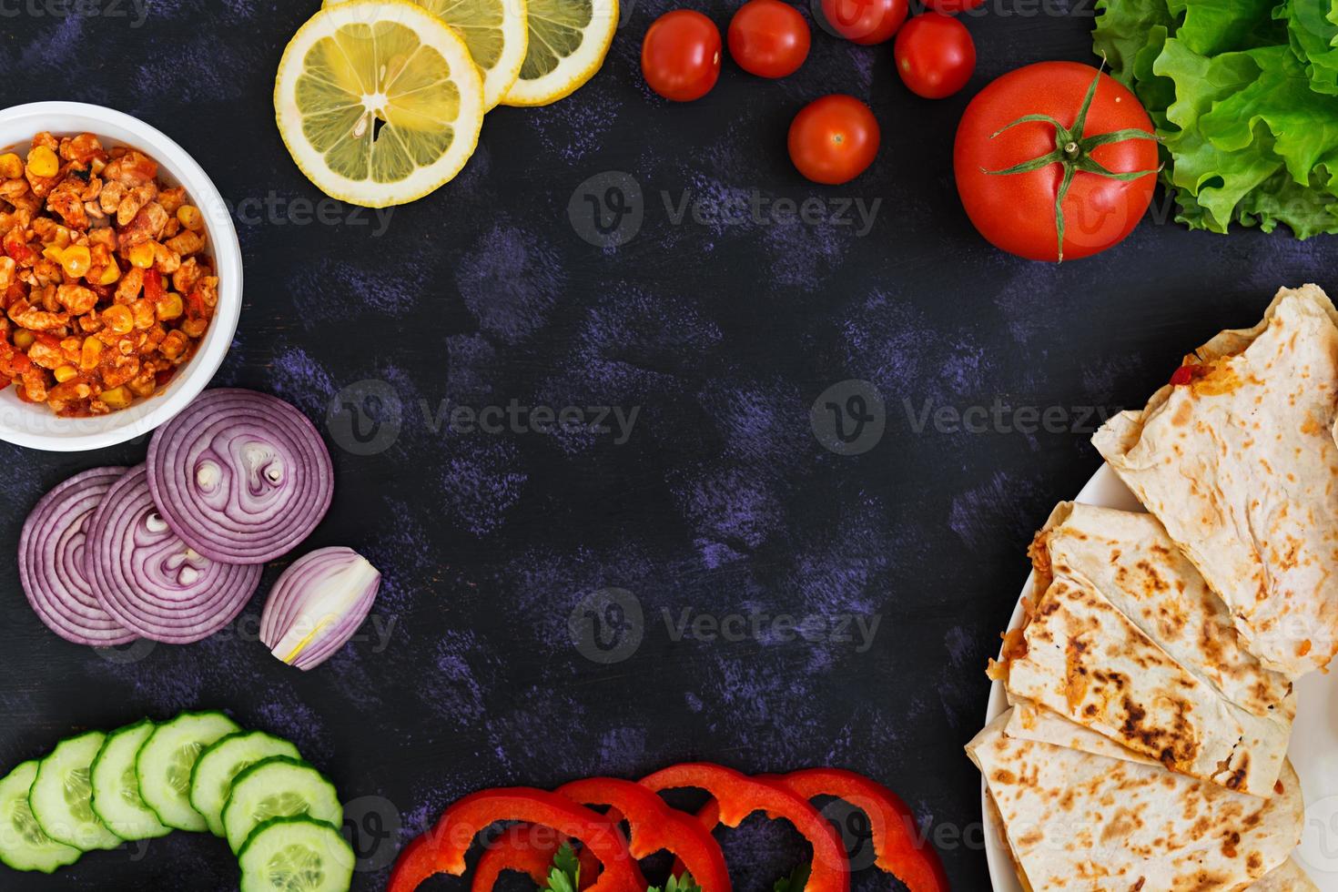 quesadilla con pollo y maíz sobre fondo oscuro. vista superior foto