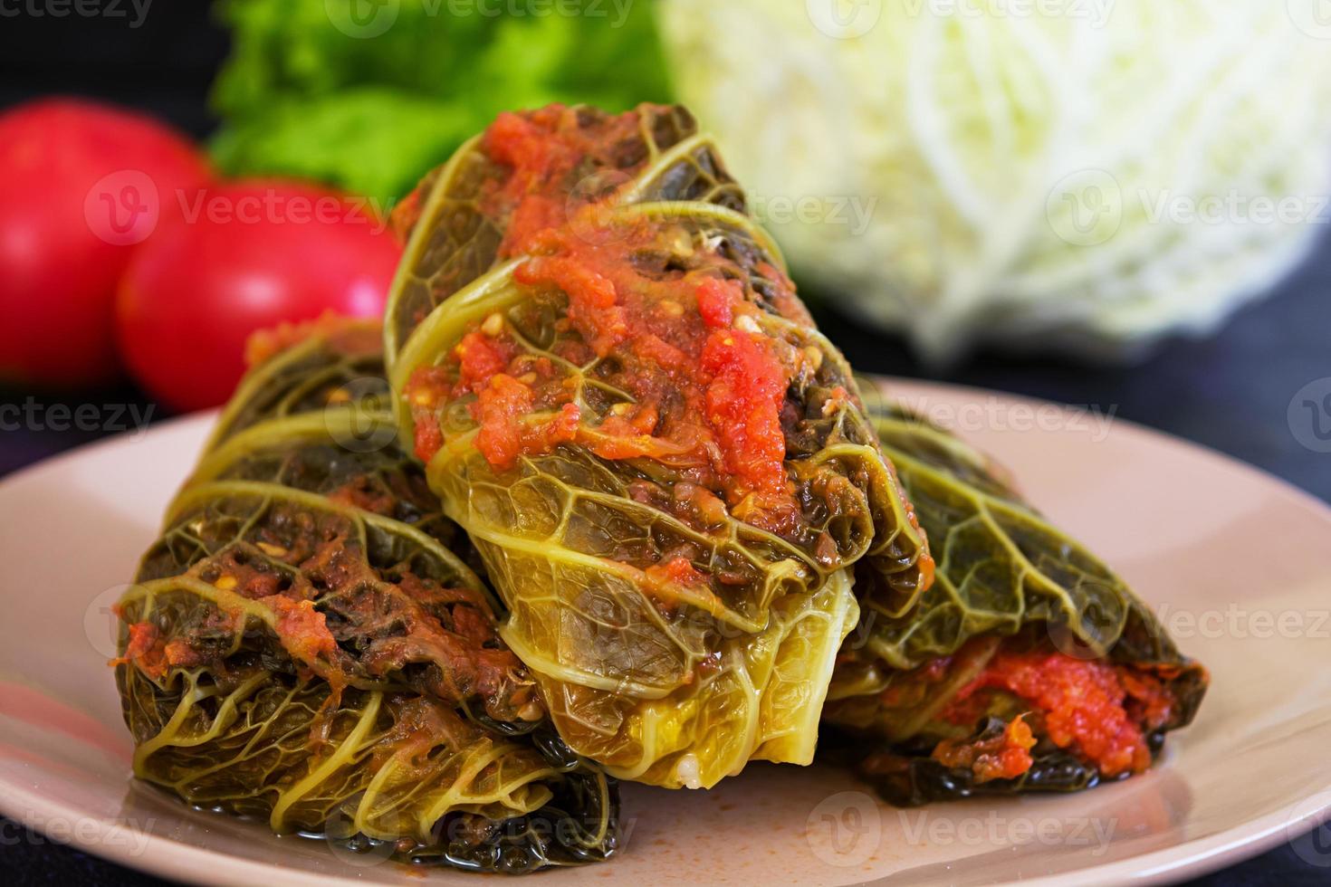 Cabbage rolls with savoy leaves on dark background photo