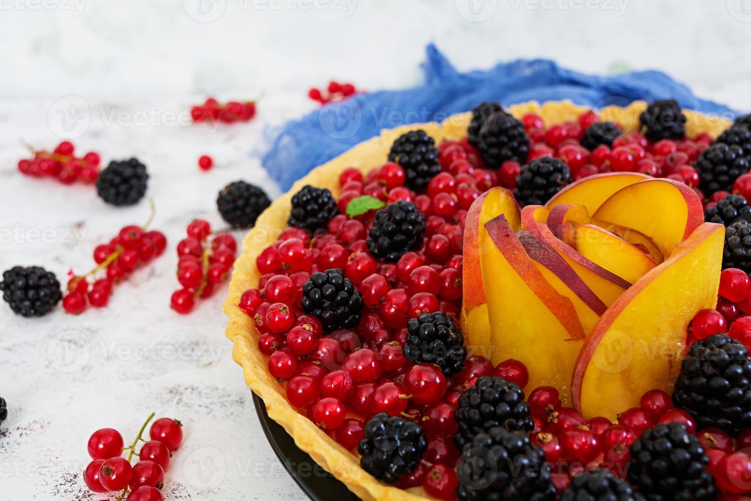 Delicious tart with red currants, peach and blackberries photo