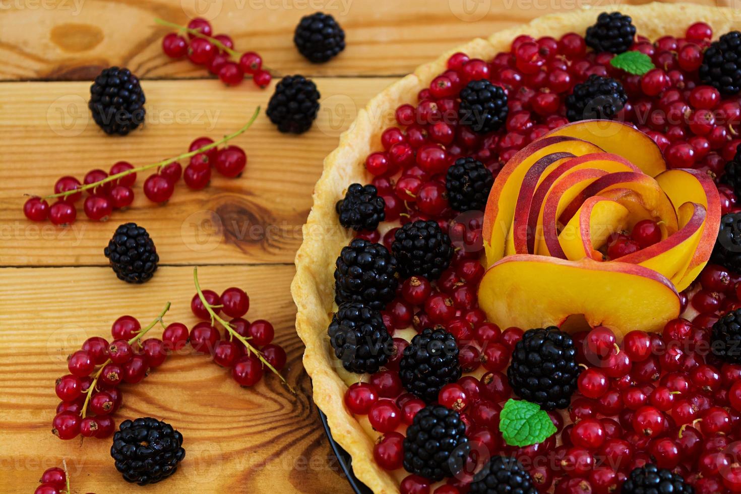 Delicious tart with red currants, peach and blackberries photo