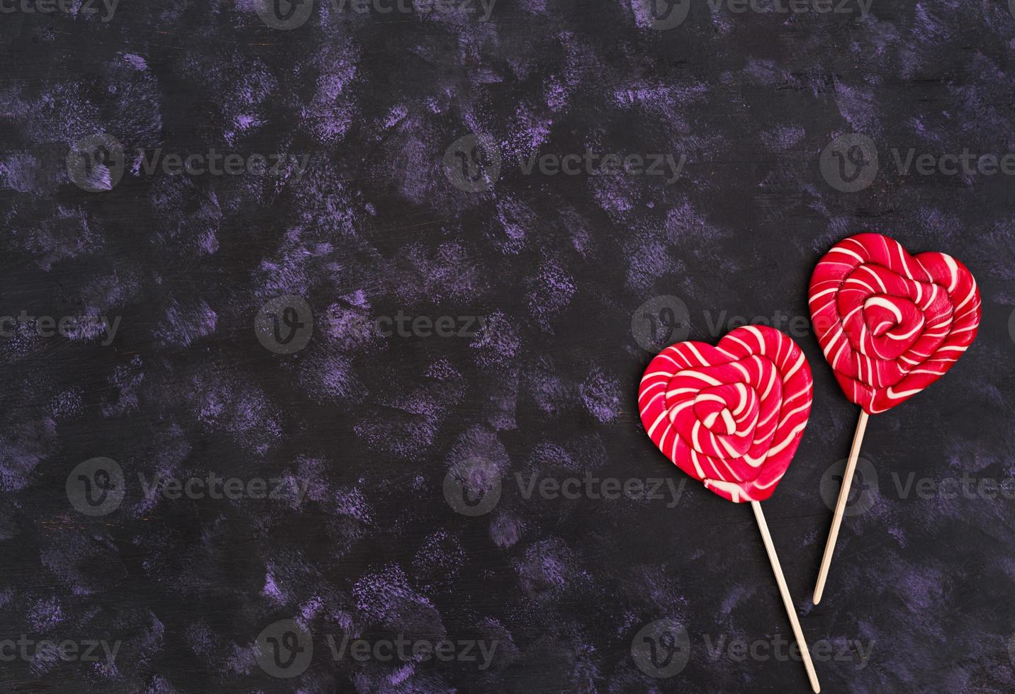 Colorful lollipops on dark background. Top view photo