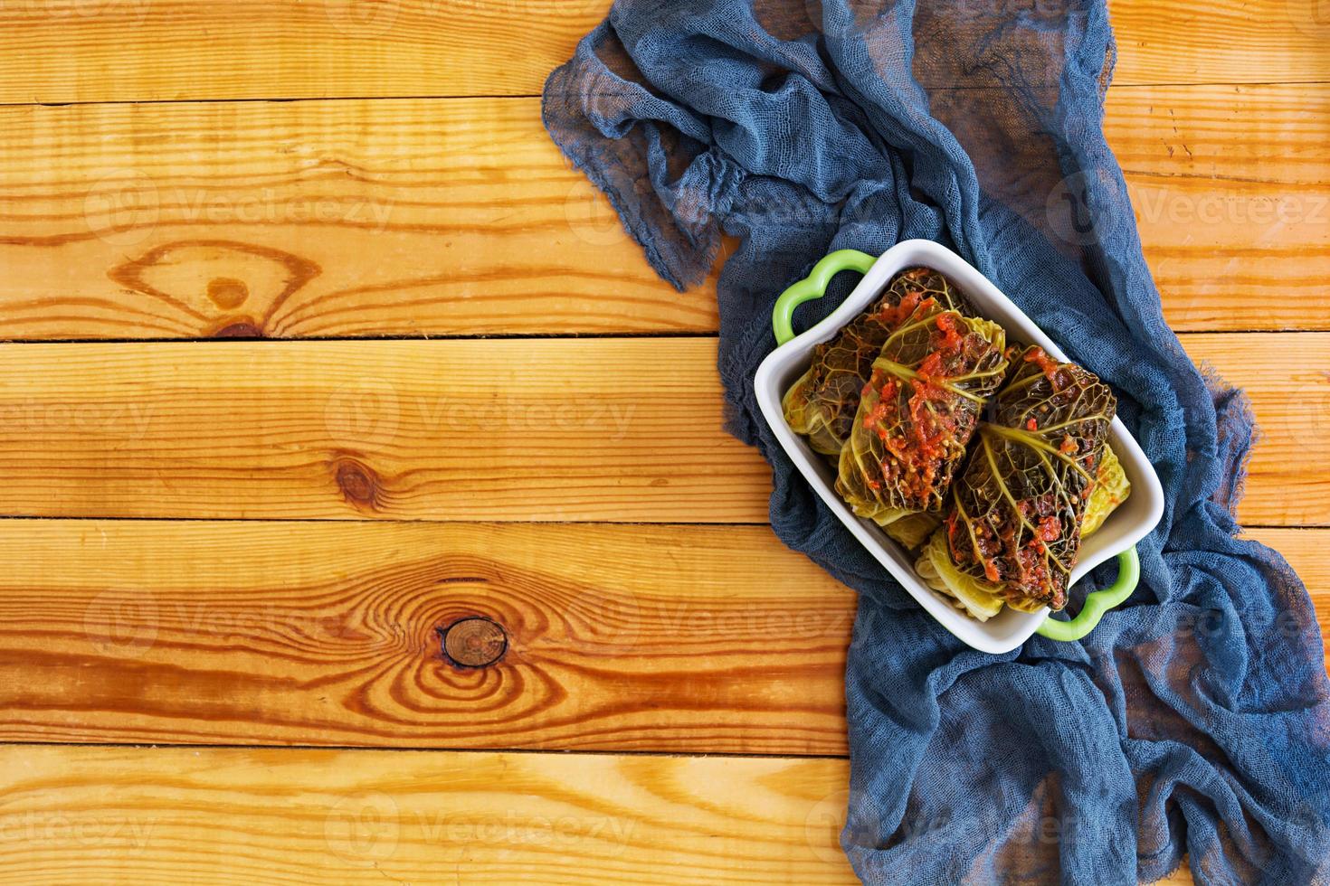 Cabbage rolls with savoy leaves on wooden background. Top view photo