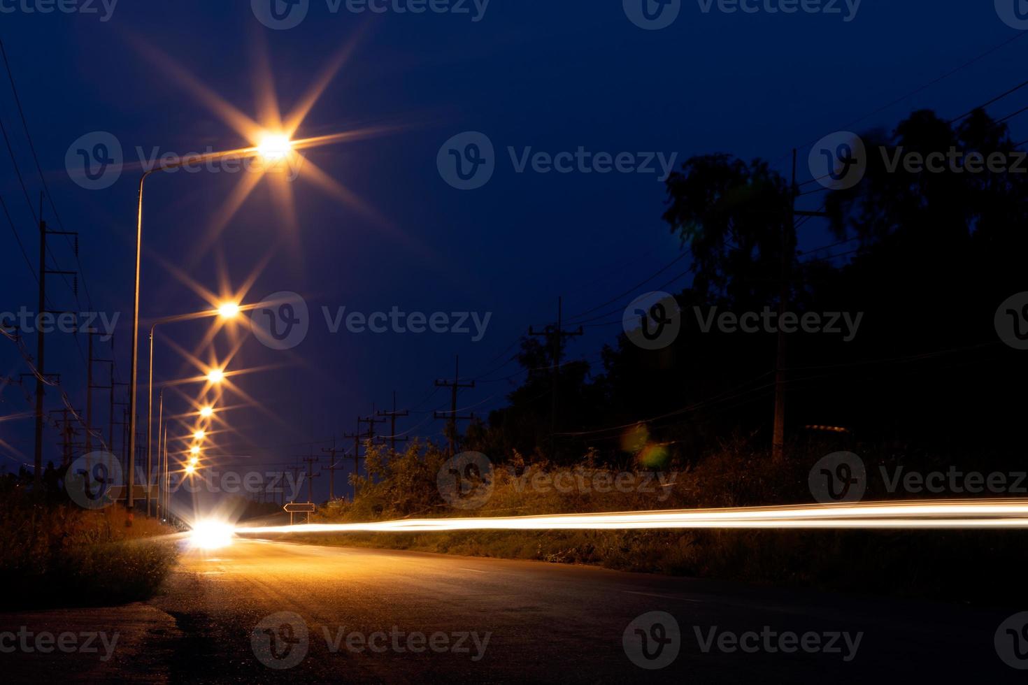 Light the lamp with the headlights on the road in the dark. photo