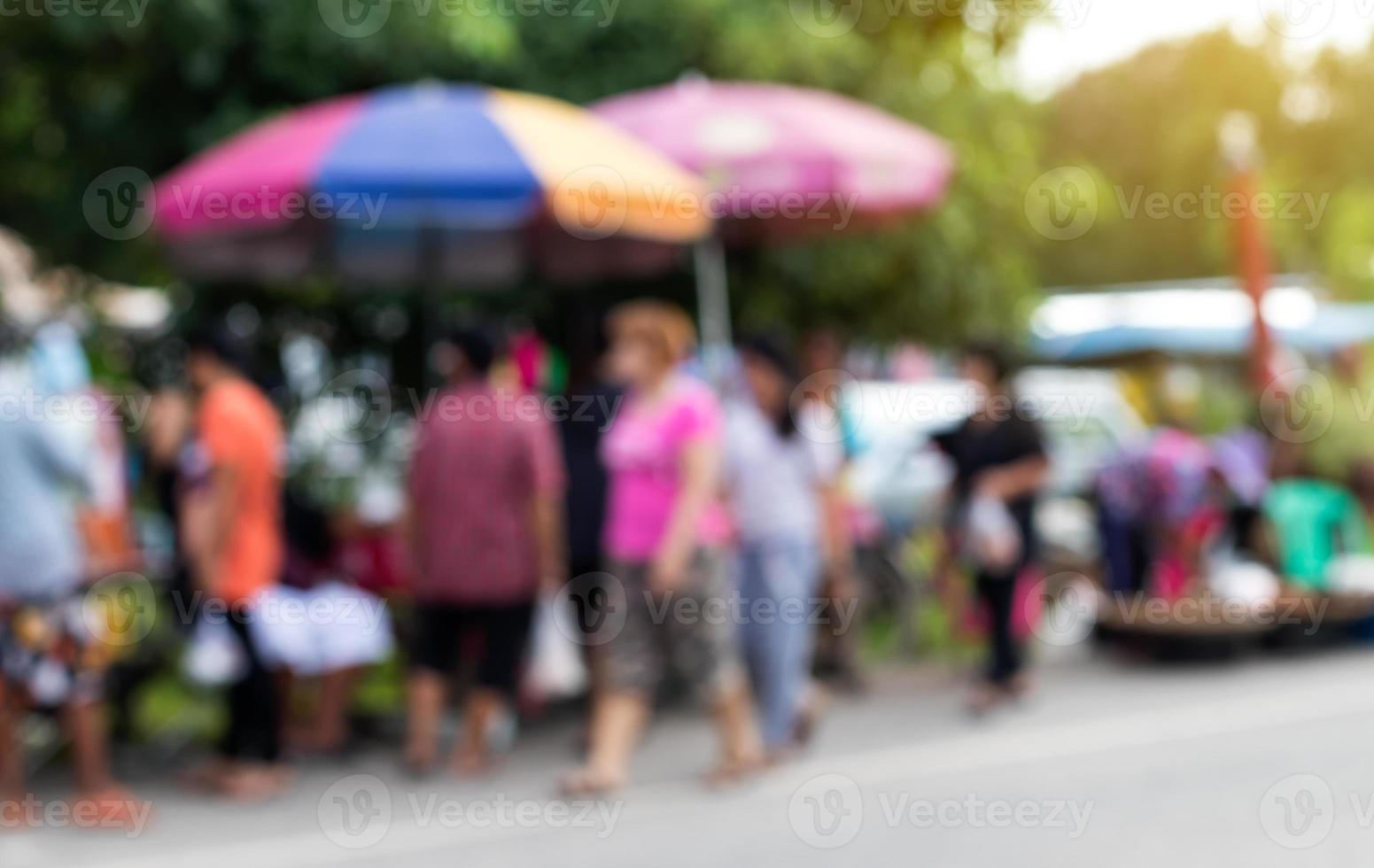 la gente borrosa se para y camina en el mercado. foto