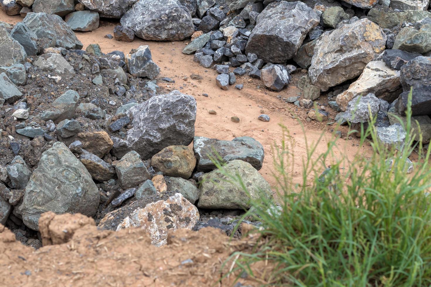 Pile of large granite stones near the grass. photo