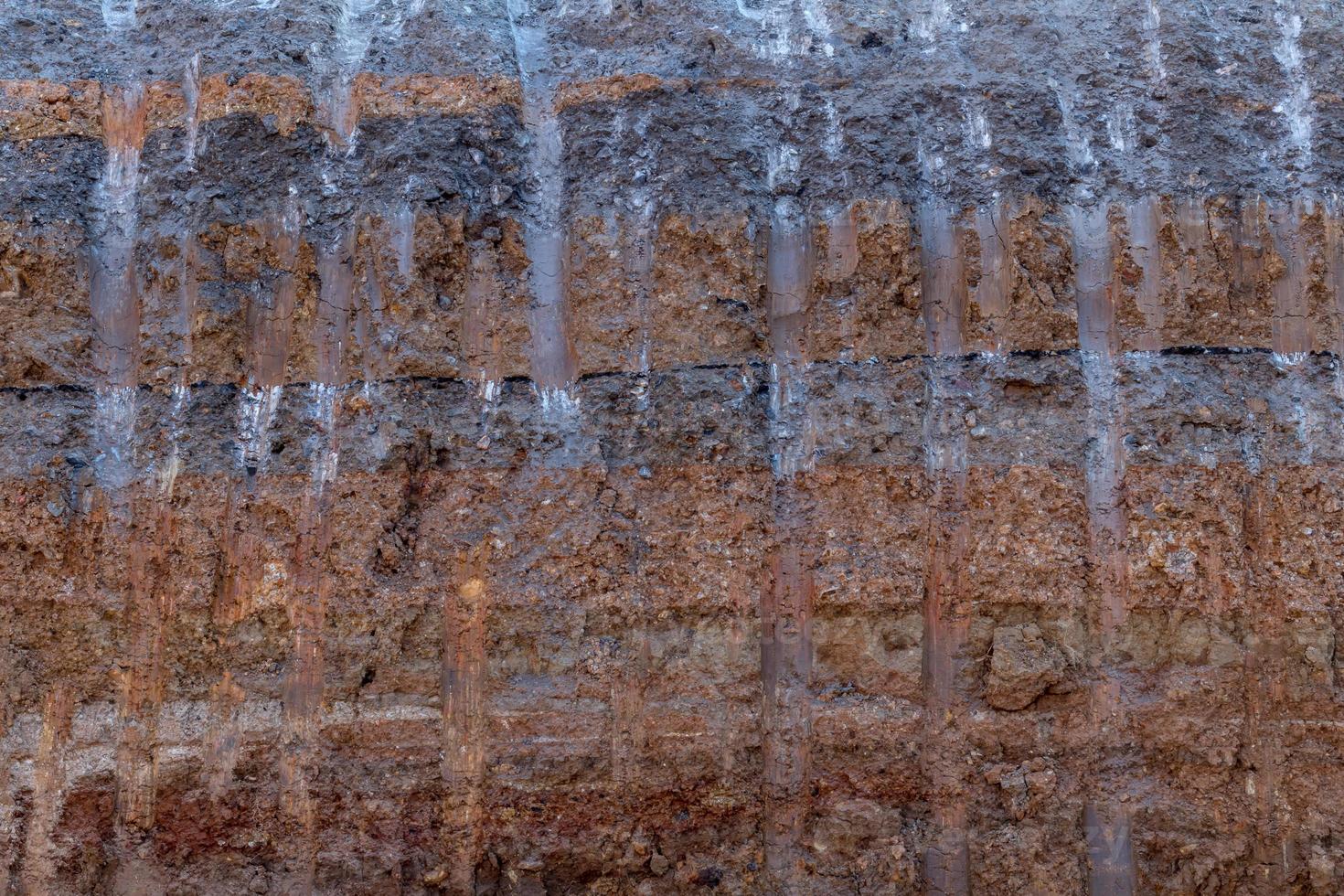 Surface soil layer under the road with digging trails. photo