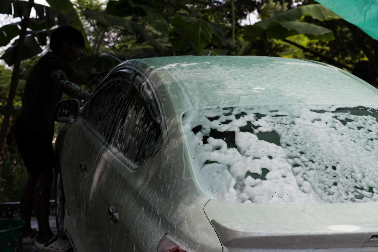 Lavado de coches en spray de espuma blanca. foto