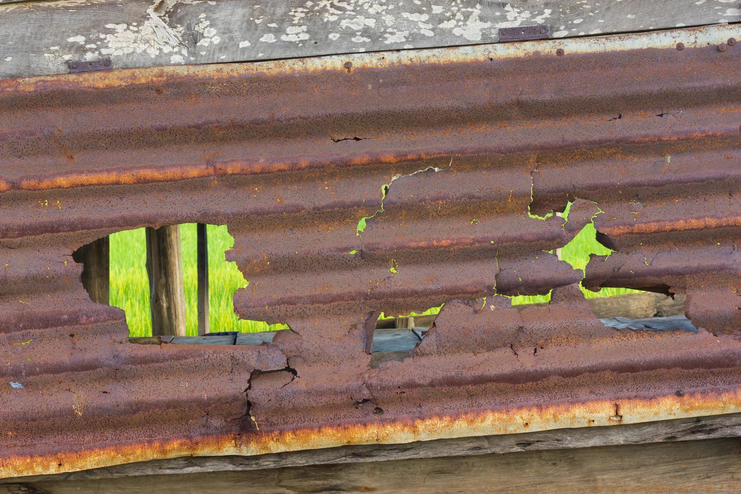 viejo agujero de hojas de zinc oxidado. foto