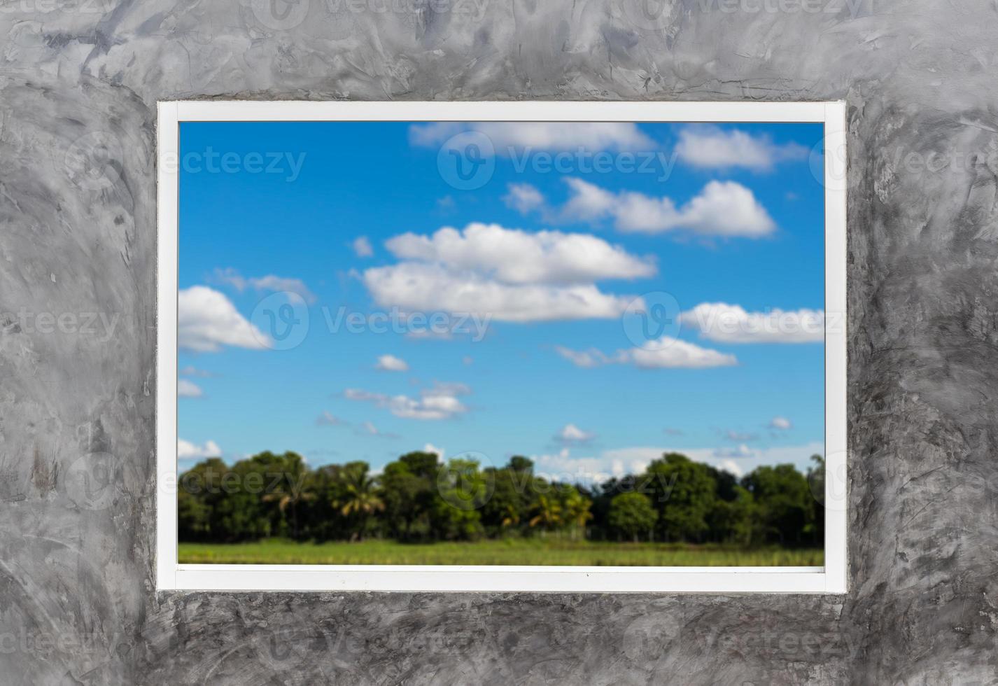 White window frames in concrete with rural sky clouds. photo