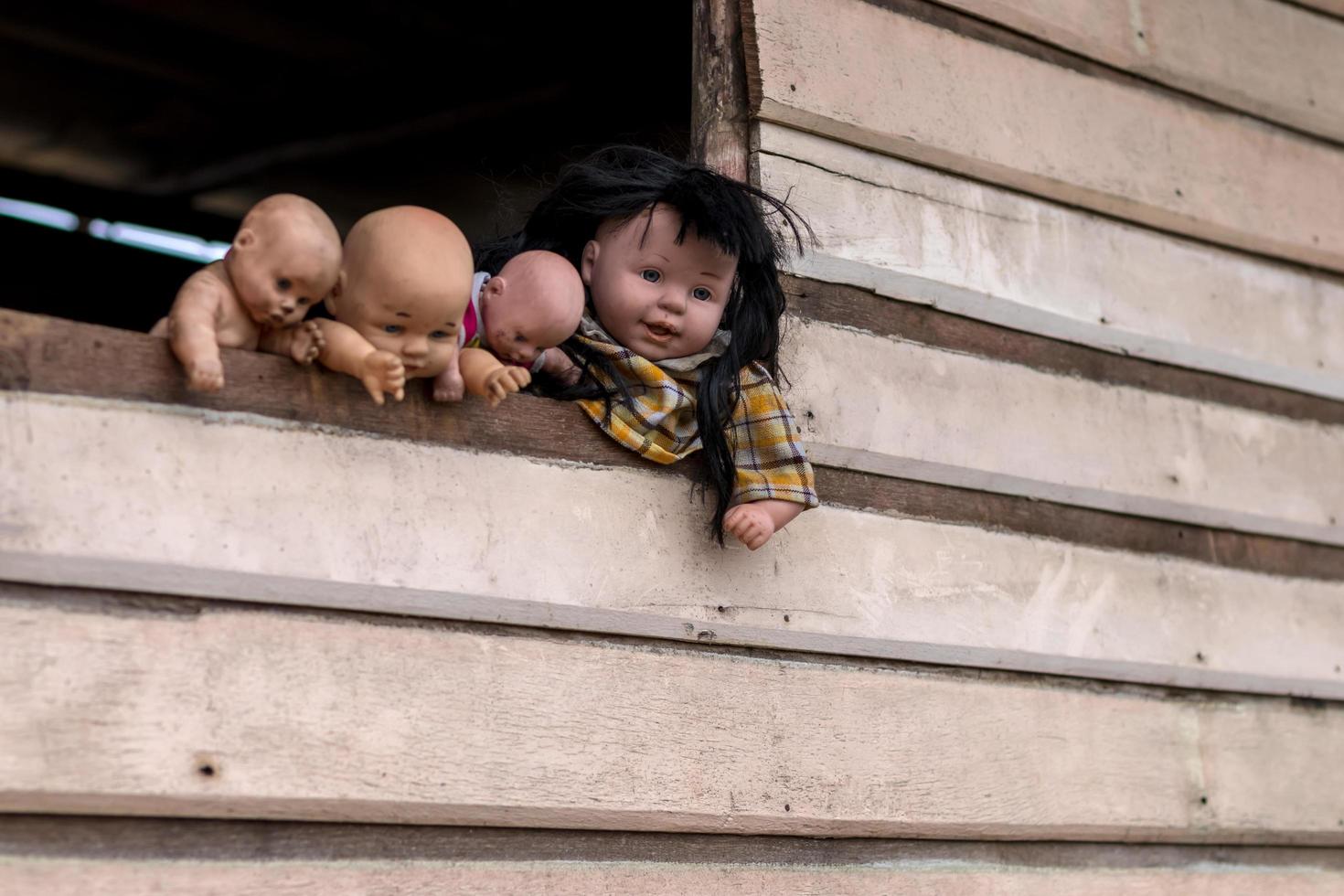 Old baby doll family on the wooden wall. photo