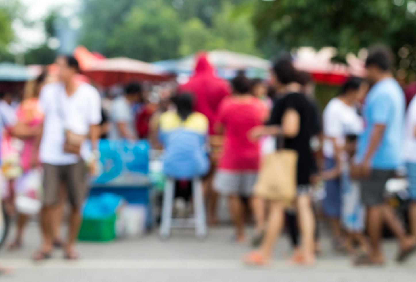 la gente borrosa se para y camina en el mercado. foto