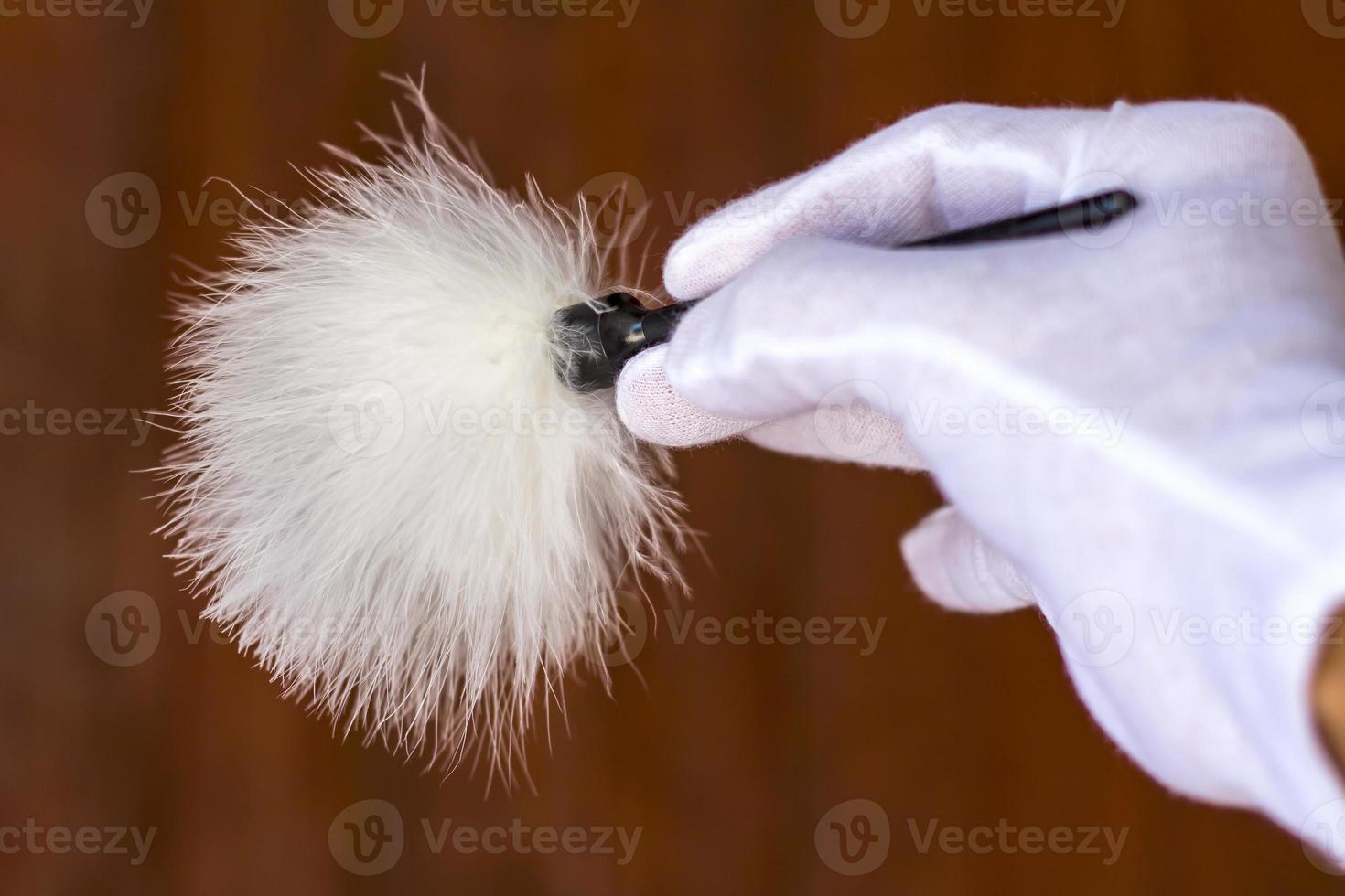 White gloved hand holding a paintbrush. photo