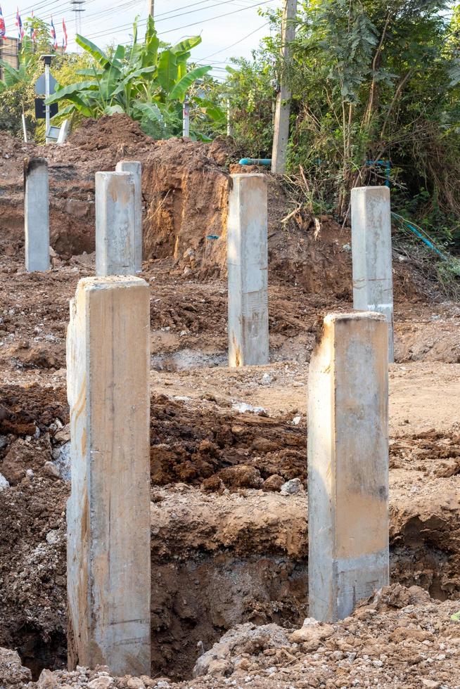 Many concrete poles in the excavated soil. photo