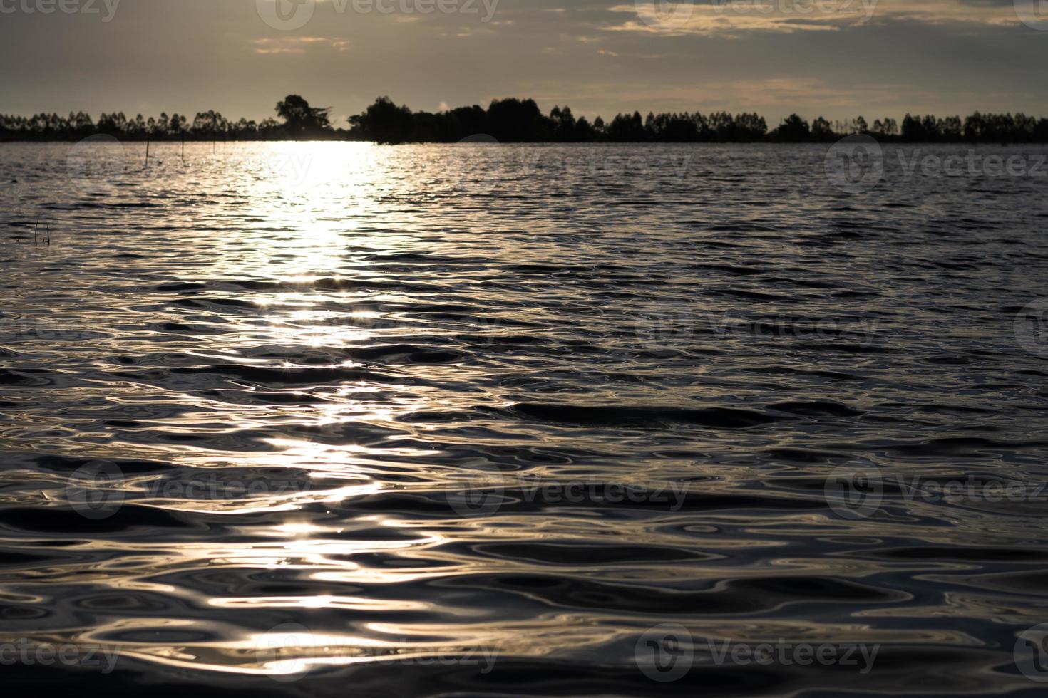 The backlit wave of water is sparkling early in the morning. photo