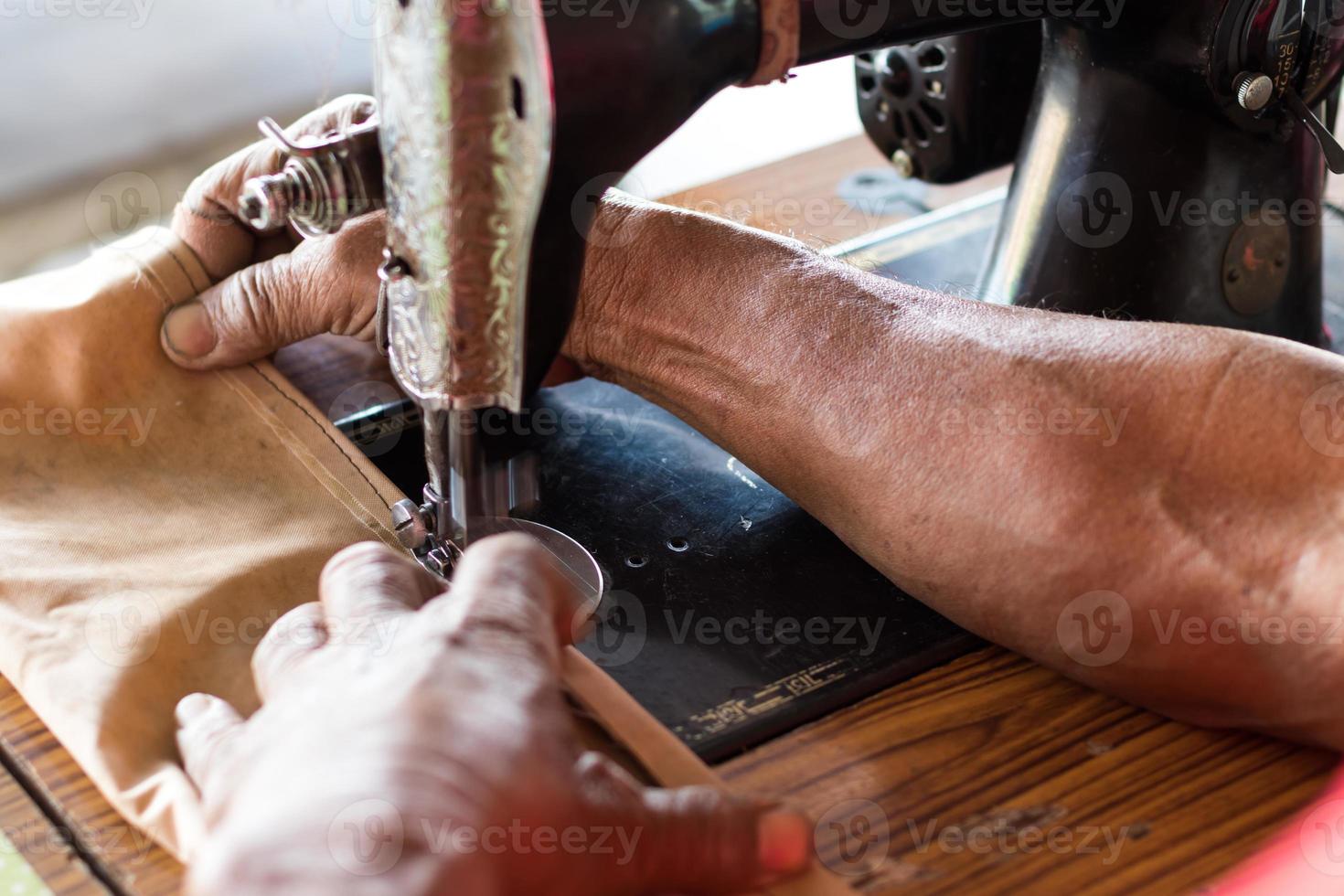 Male hand with old sewing machine. photo