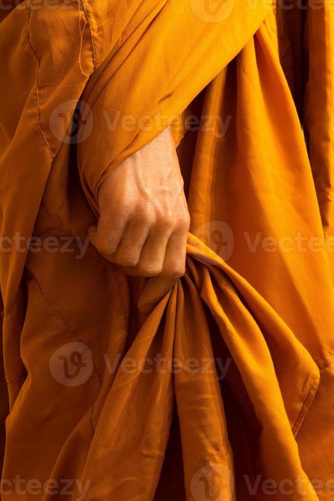 Close-up of monk hands holding his robes. photo