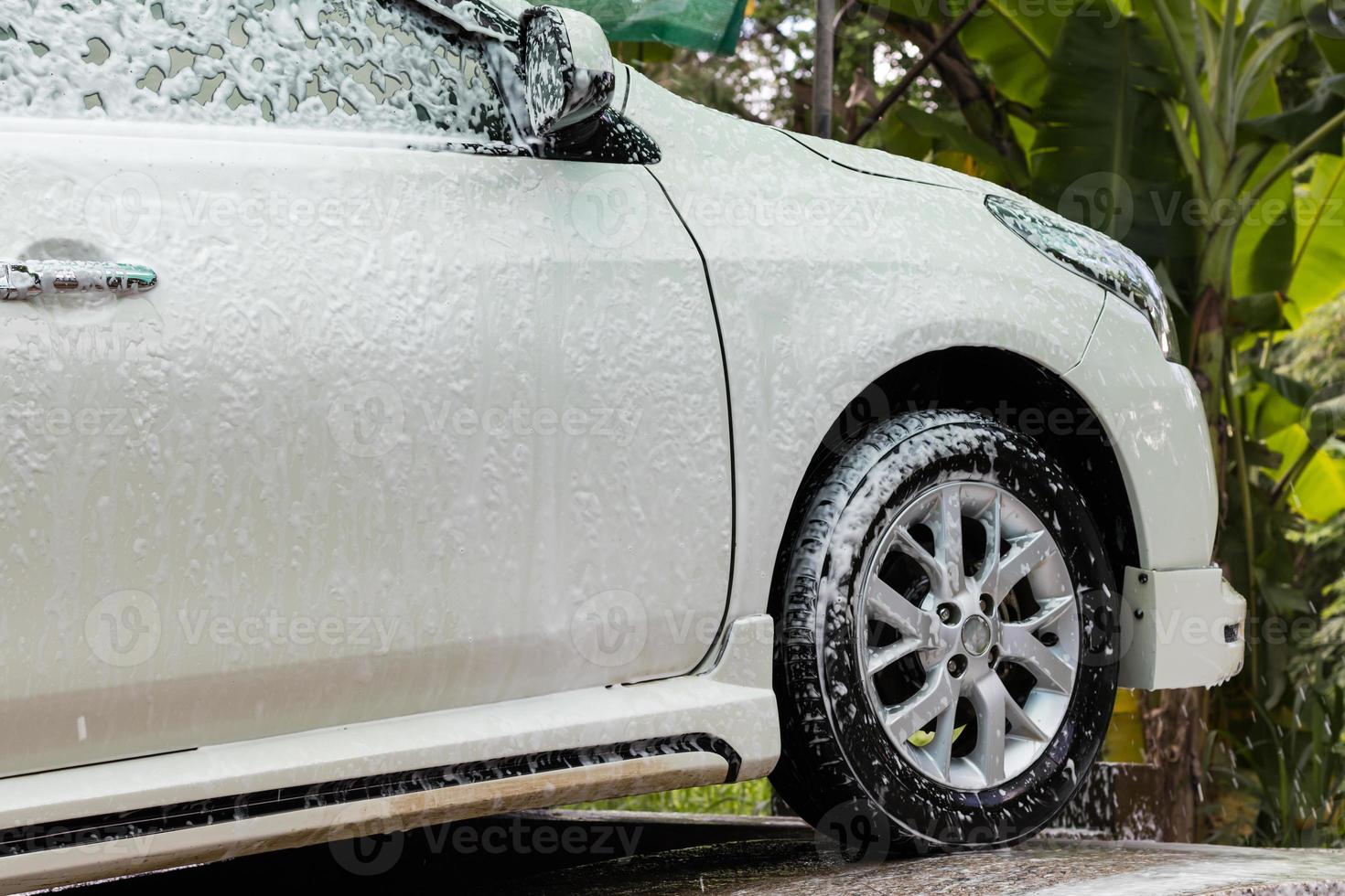 Lavado de coches en spray de espuma blanca. foto