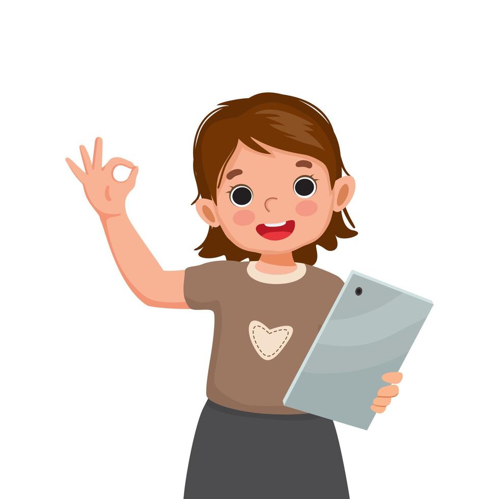 linda niña sosteniendo y usando una tableta digital sonriendo mostrando un gesto de signo ok. concepto de niños y dispositivos electrónicos para niños vector