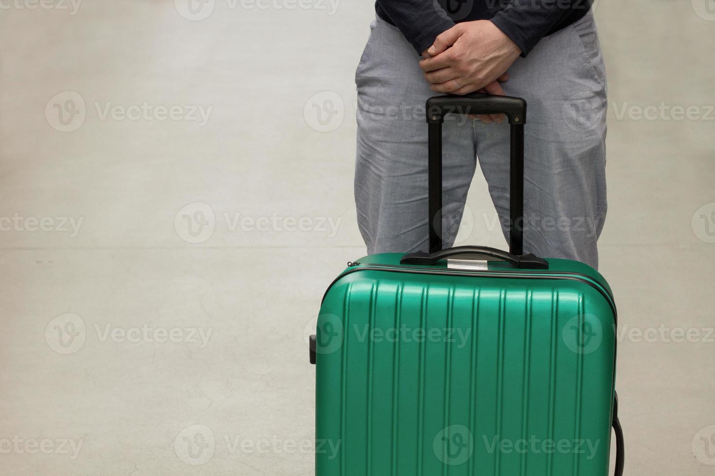 Waiting at the airport. The concept of summer vacation, a traveler with a suitcase in the waiting area of the airport terminal. Selective focus. photo