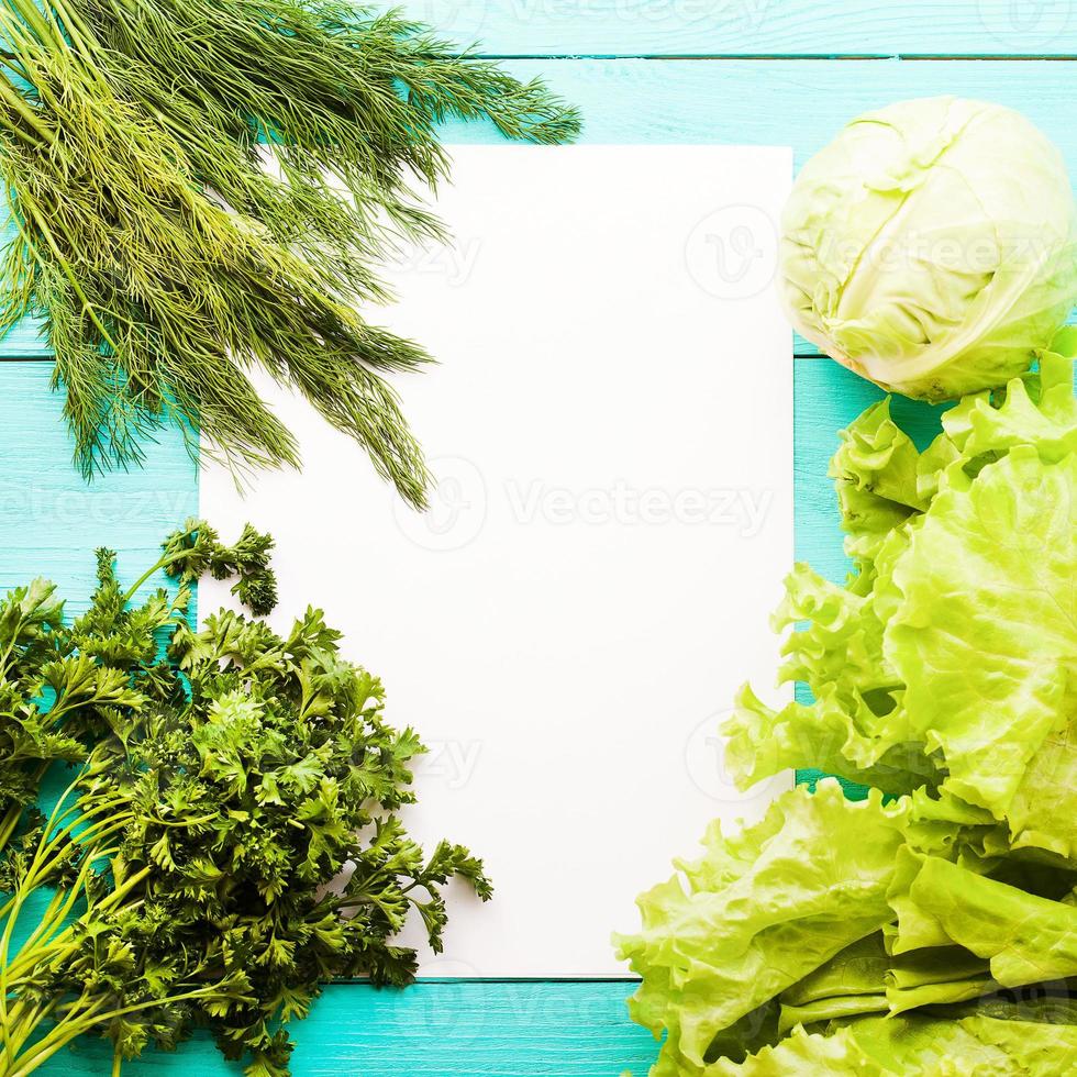 Different vegetables on kitchen table with recipe list and copy space. Top view photo