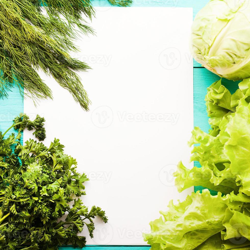 Different vegetables on kitchen table with recipe list and copy space. Top view photo