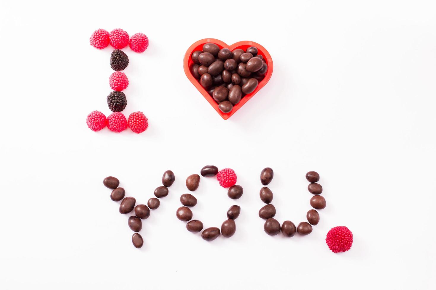 Candy and sweets isolated on white background. Heart shape. Top view. Selective focus. Copy space and mock up photo