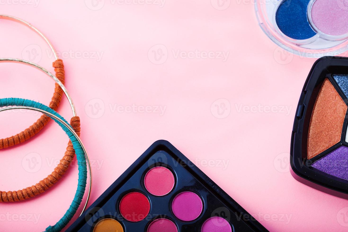 Frame of cosmetic accessories on pink background with copy space. Top view photo
