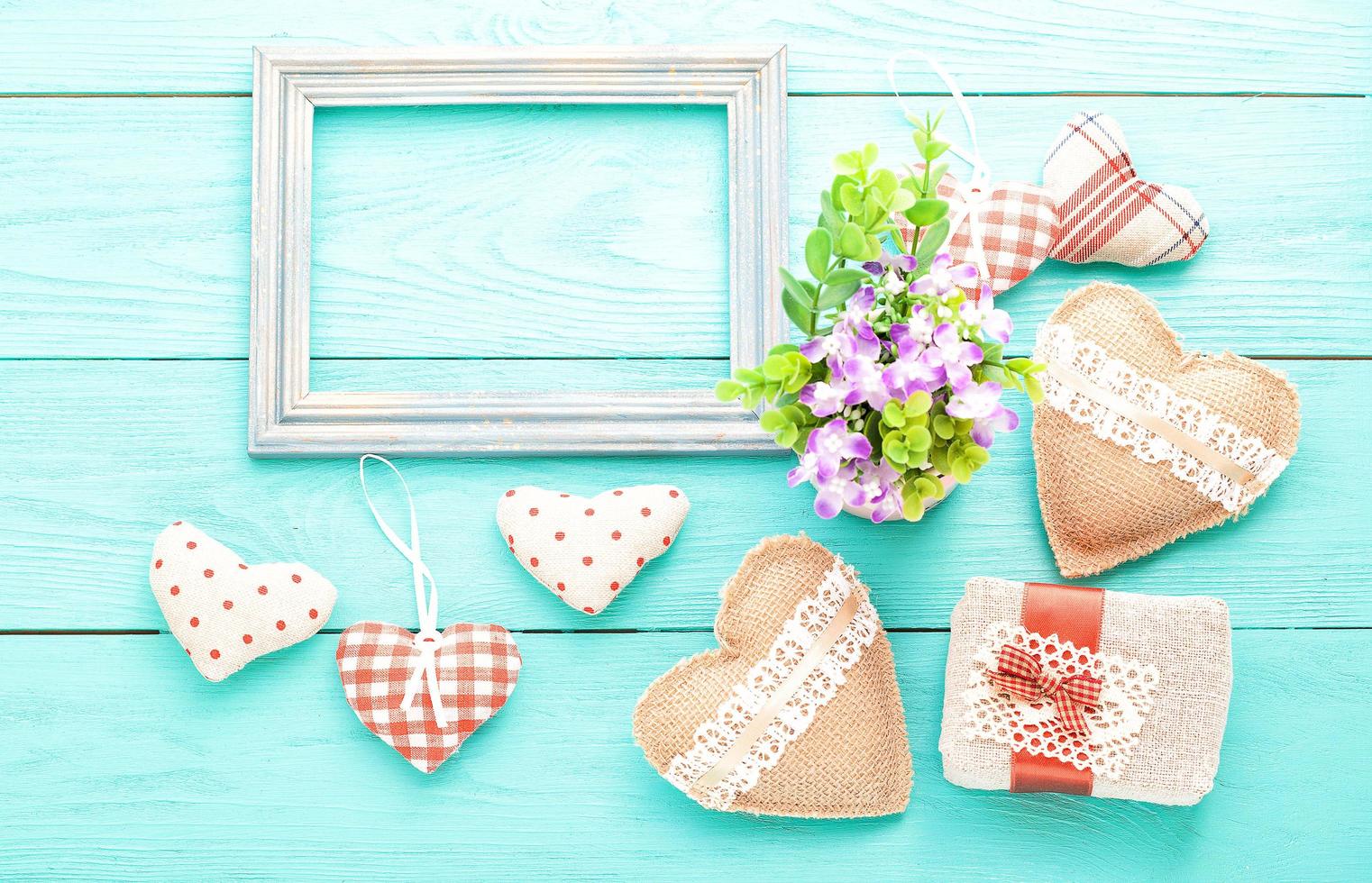 Frame and hearts on blue wooden background. Top view and copy space. Valentines day photo