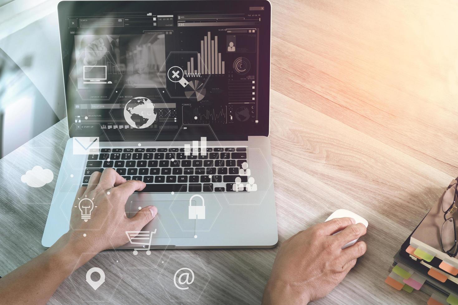 hombre de negocios que trabaja con computadora portátil y tableta digital y libro y documento en un escritorio de madera en una oficina moderna con interfaz de iconos virtuales foto