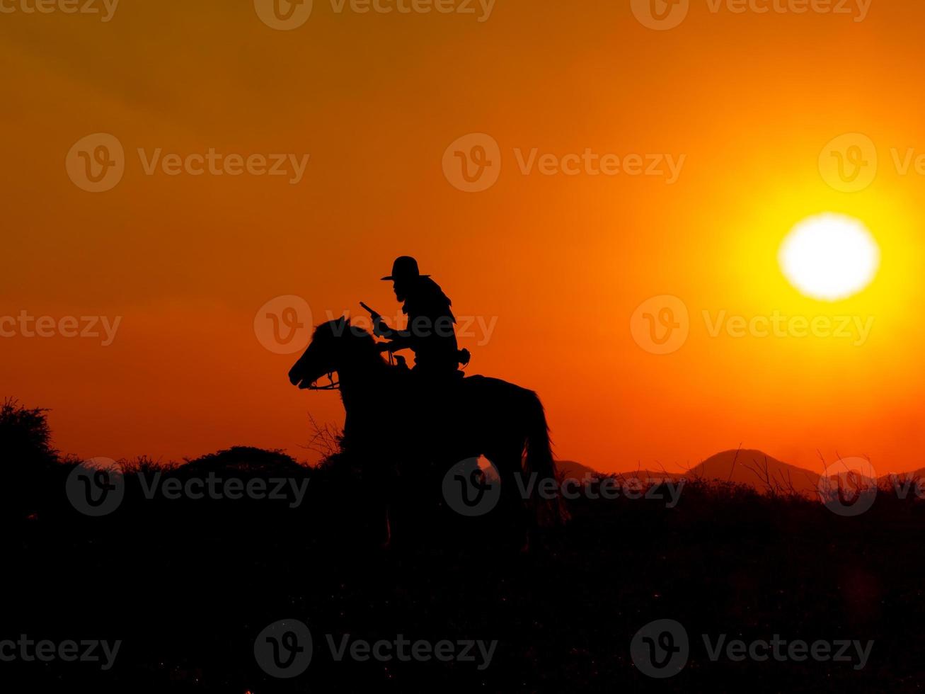 The Western Cowboy forced his horses to stop while the sun was setting, In lands where the law has not yet reached photo