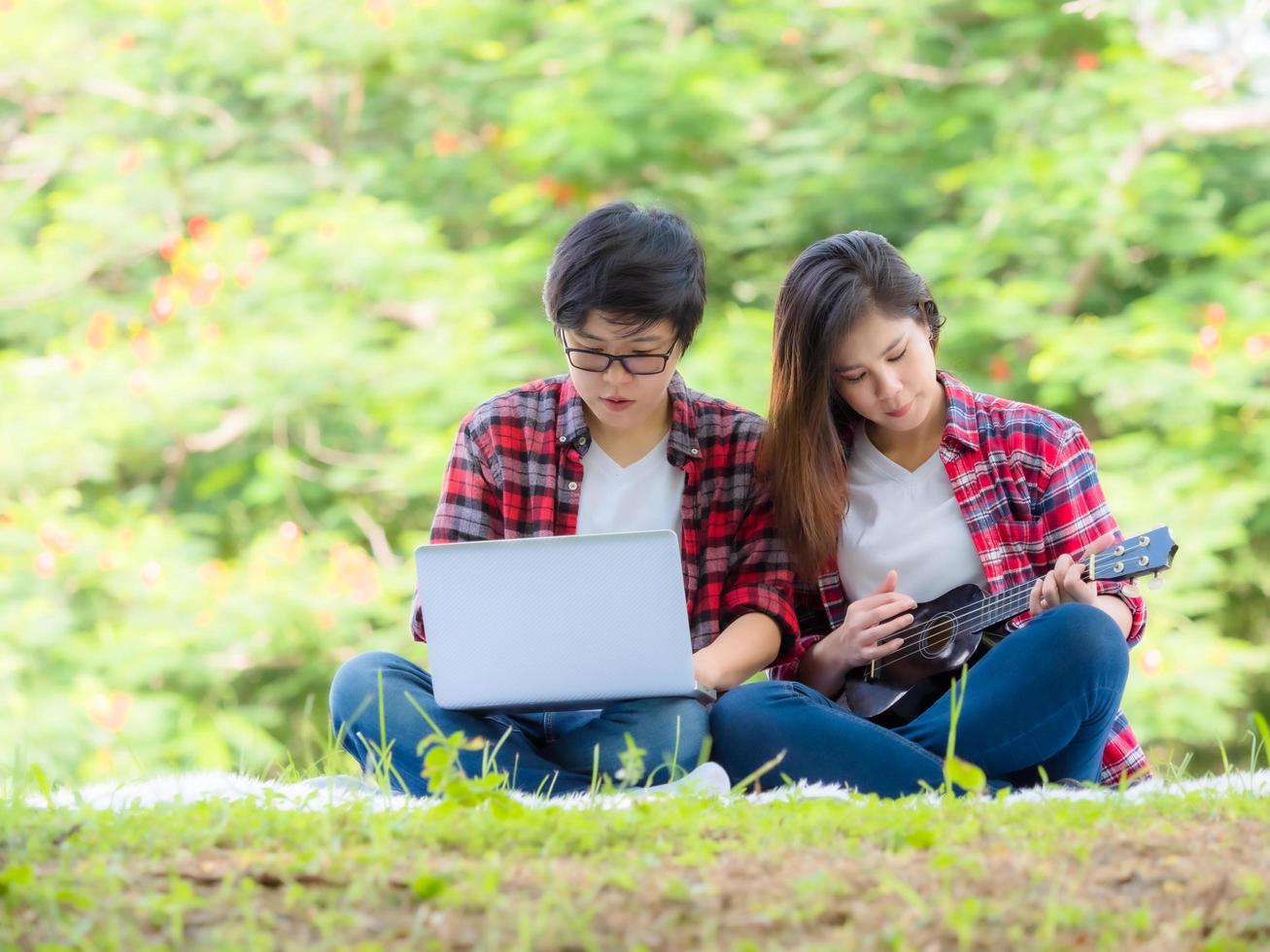 Asian female couples LGBT learn to play ukulele in the garden with love and happiness photo