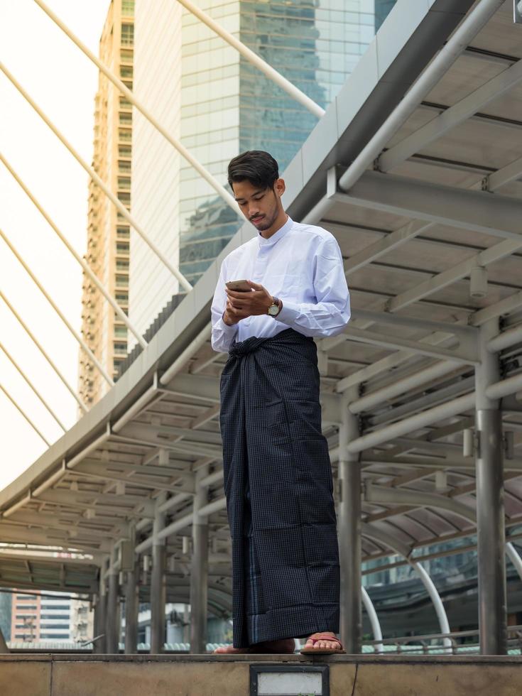 Young Burmese businessman using mobile phone to find a data for his business photo